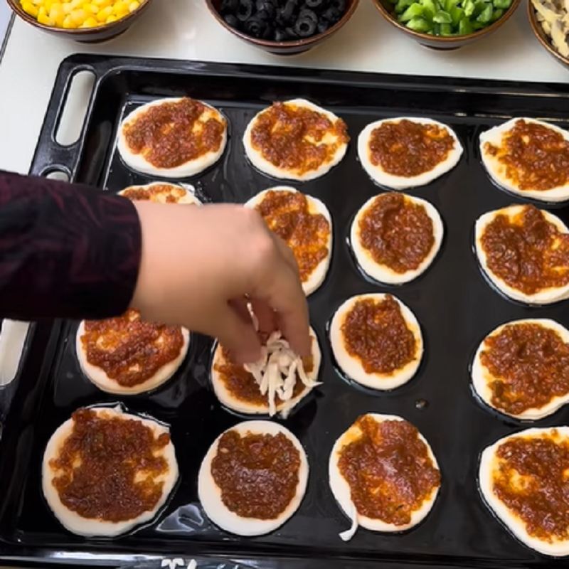 افزودن سس و مواد روی پیتزا